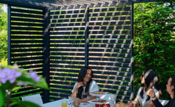 Familie genießt Schatten unter moderner Lamellen Pergola