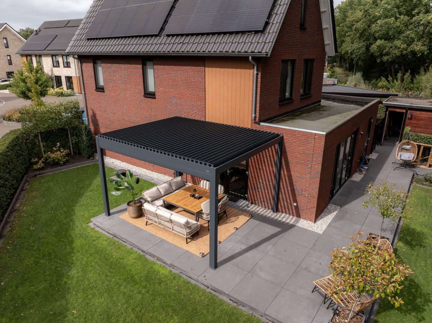 Hochwertige outdoor Lounge unter einer stilvollen Gartenpergola, perfekt für entspannte Momente im Grünen, ideal für moderne Hausgarten-Designs.